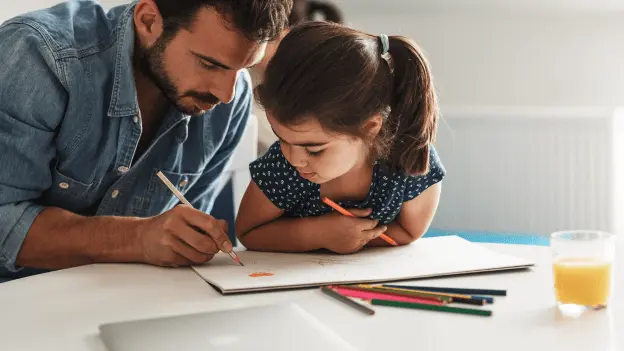A father and daughter draw with color pencils.
