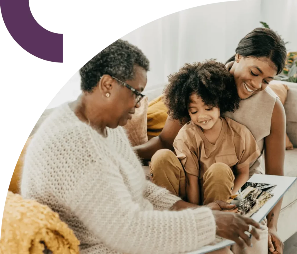 Grandmother reads to a child with mom looking on.