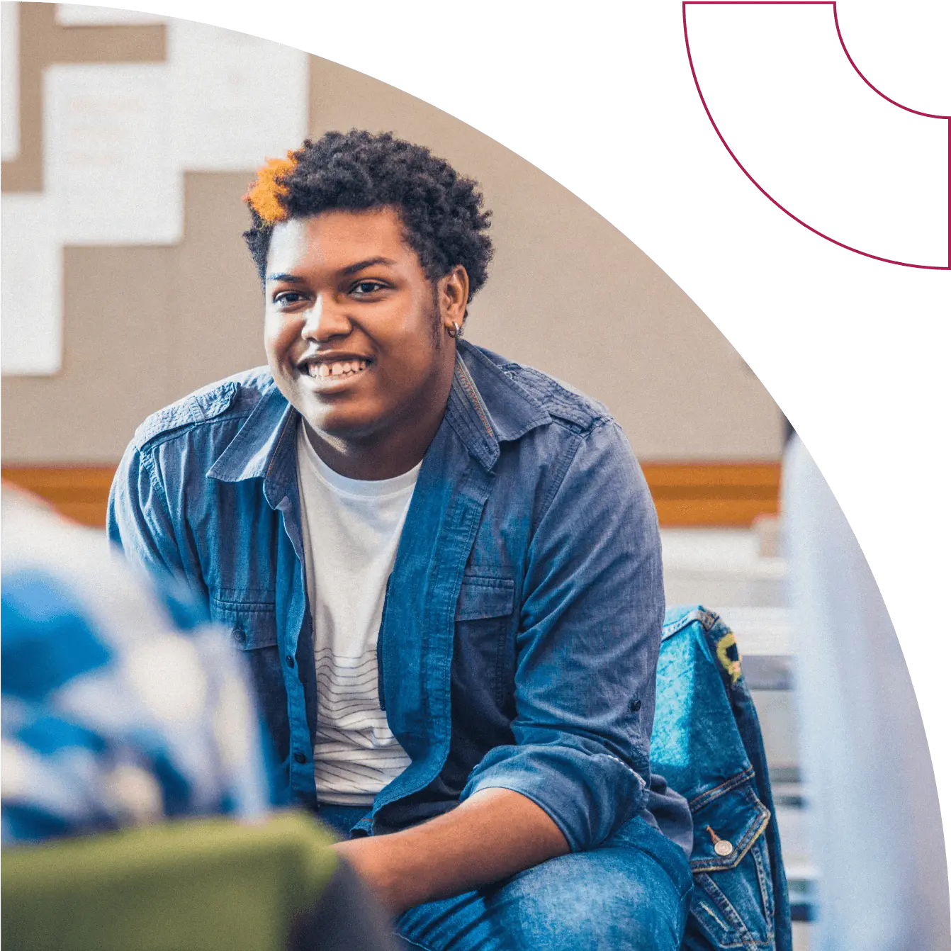 A youth sits down and smiles