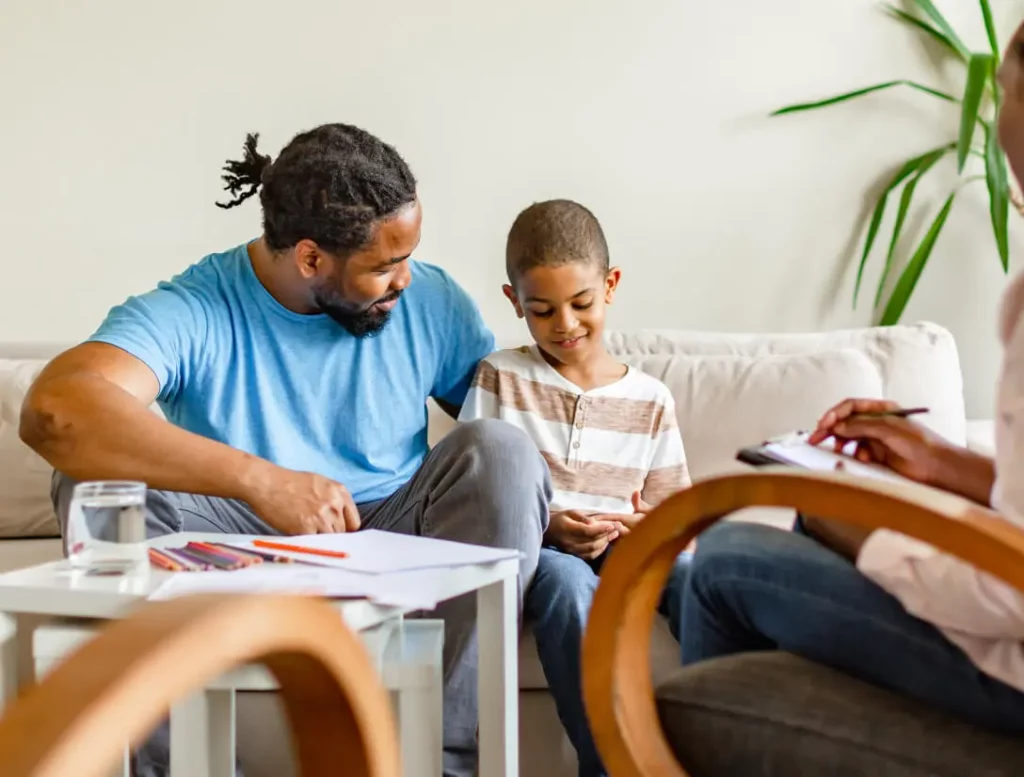 An adult and child have a conversation on a couch.