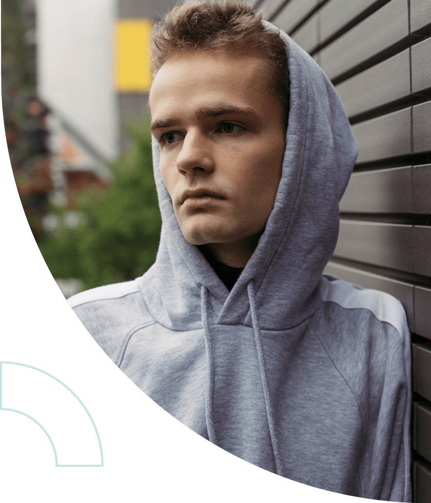 A teen in a gray hoodie looking to the side. 